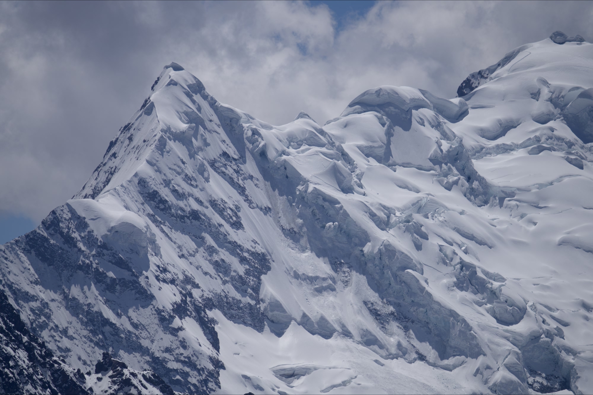Glaciers meeting the side of the snowy mountain peaks of the Salkantay Trail in Peru