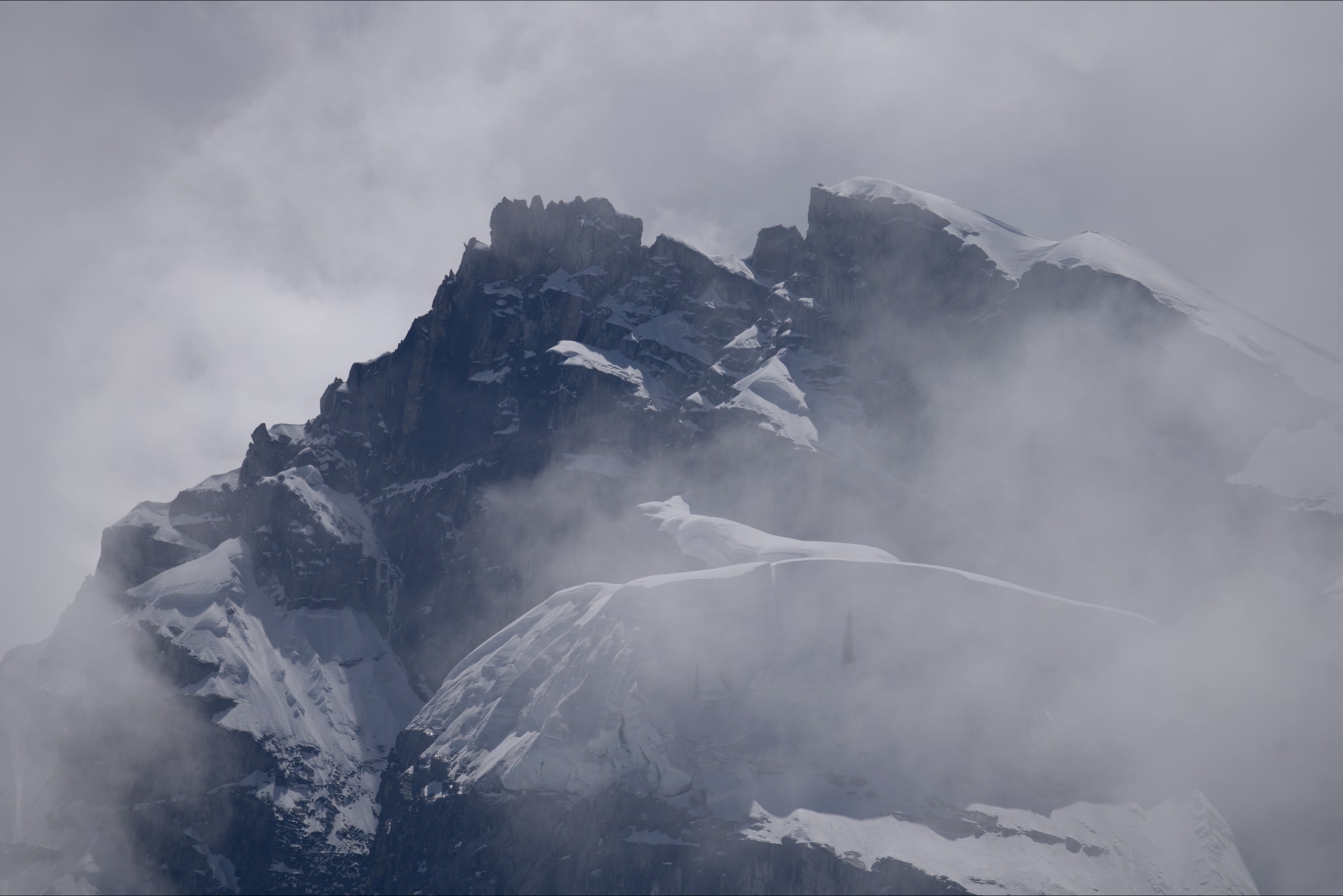 Jagged mountain peaks emerge from the clouds in the Salkantay region of Peru